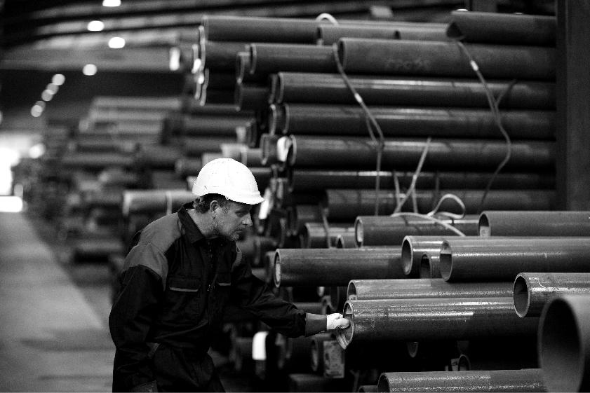 Employee inspecting steel pipe